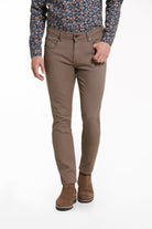 Tan slim-fit trousers made of a smooth, durable fabric with classic stitching and belt loops.