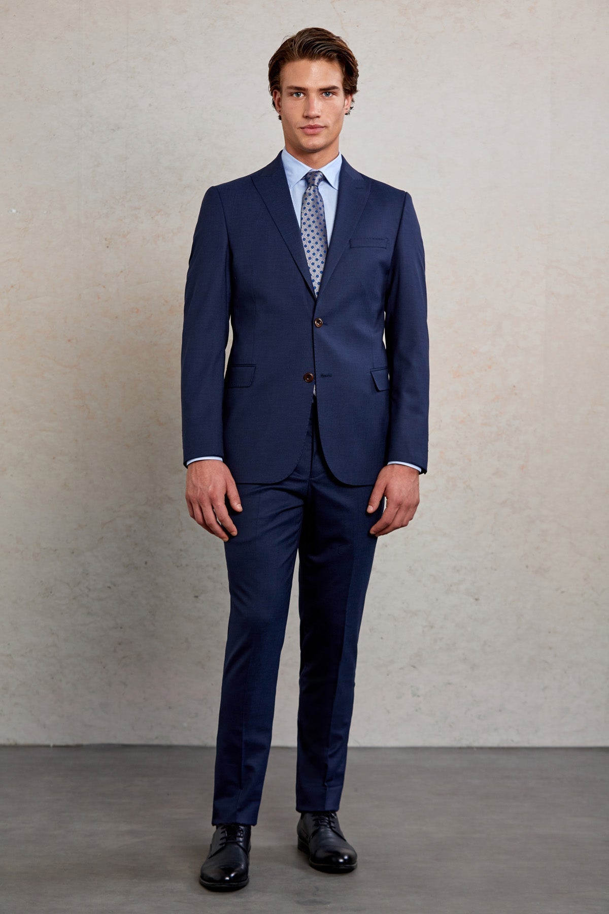 Navy blue tailored suit with a subtle sheen and classic two-button front