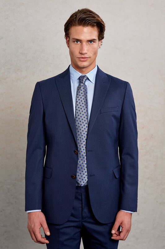Navy blue tailored suit with matching trousers and a light blue dress shirt paired with a patterned tie