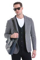 Gray textured blazer with black vest and white t-shirt underneath