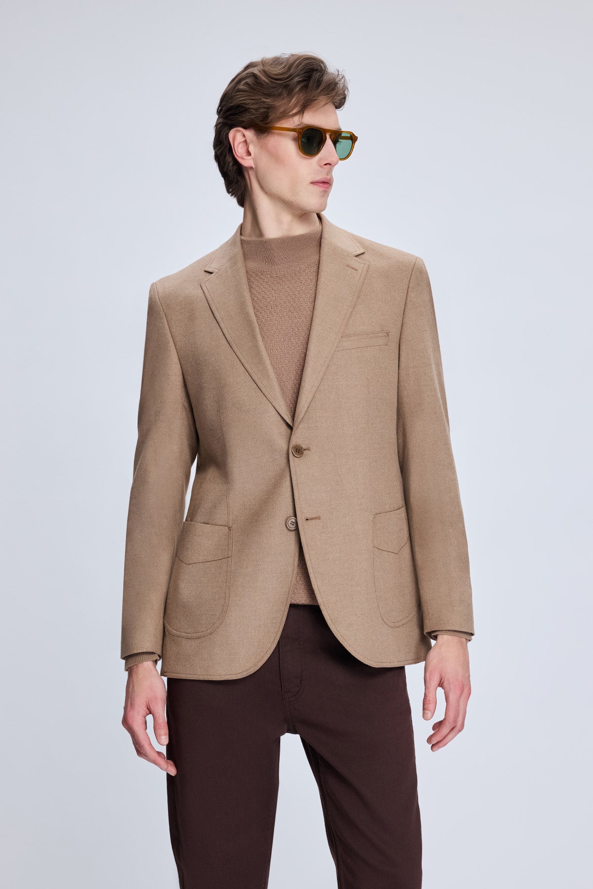 A tailored camel-colored blazer with a single-breasted design and two-button closure.