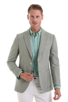 A sleek, light sage green blazer with a tailored fit and subtle texture.