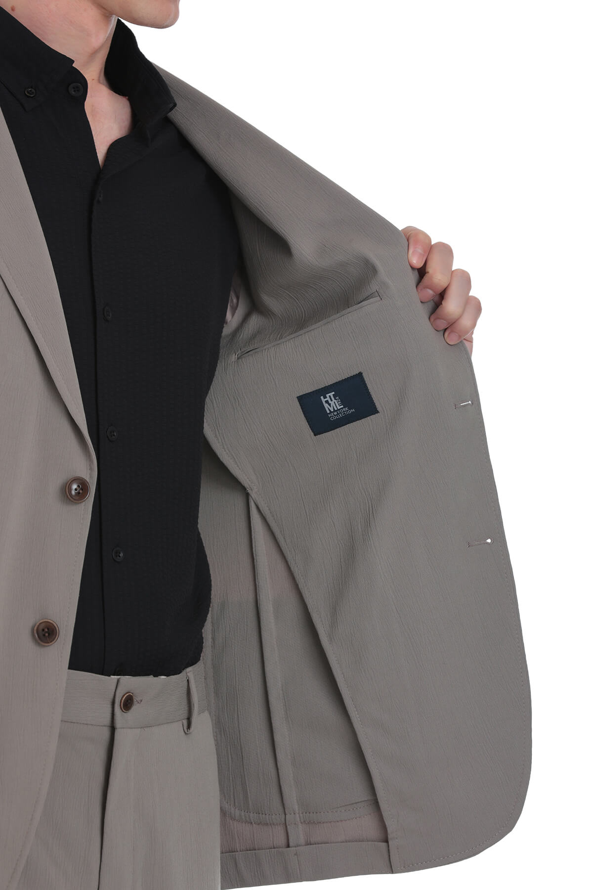 Beige tailored blazer with subtle texture and dark brown buttons.