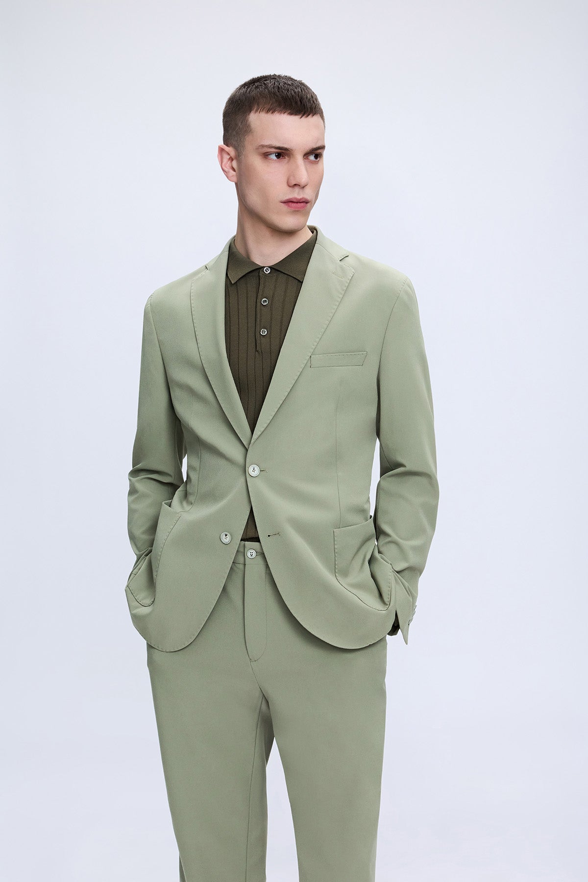Slim fit notch lapel sage green casual suit with tailored jacket and matching trousers worn with a button-down shirt