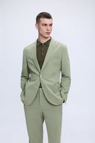 Slim fit notch lapel sage green casual suit with tailored jacket and matching trousers worn with a button-down shirt