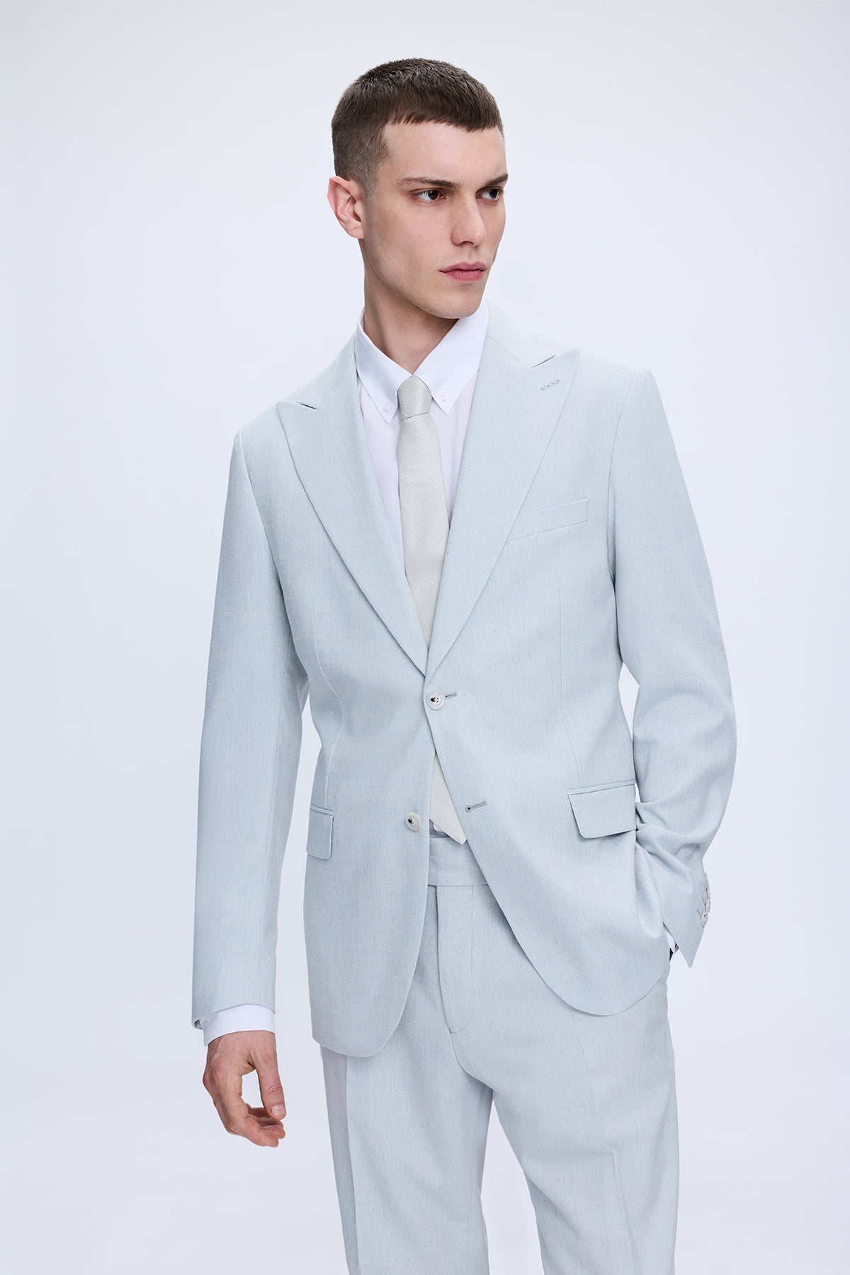 Slim fit peak lapel light blue linen-cotton suit with a sleek tailored modern cut and subtle texture