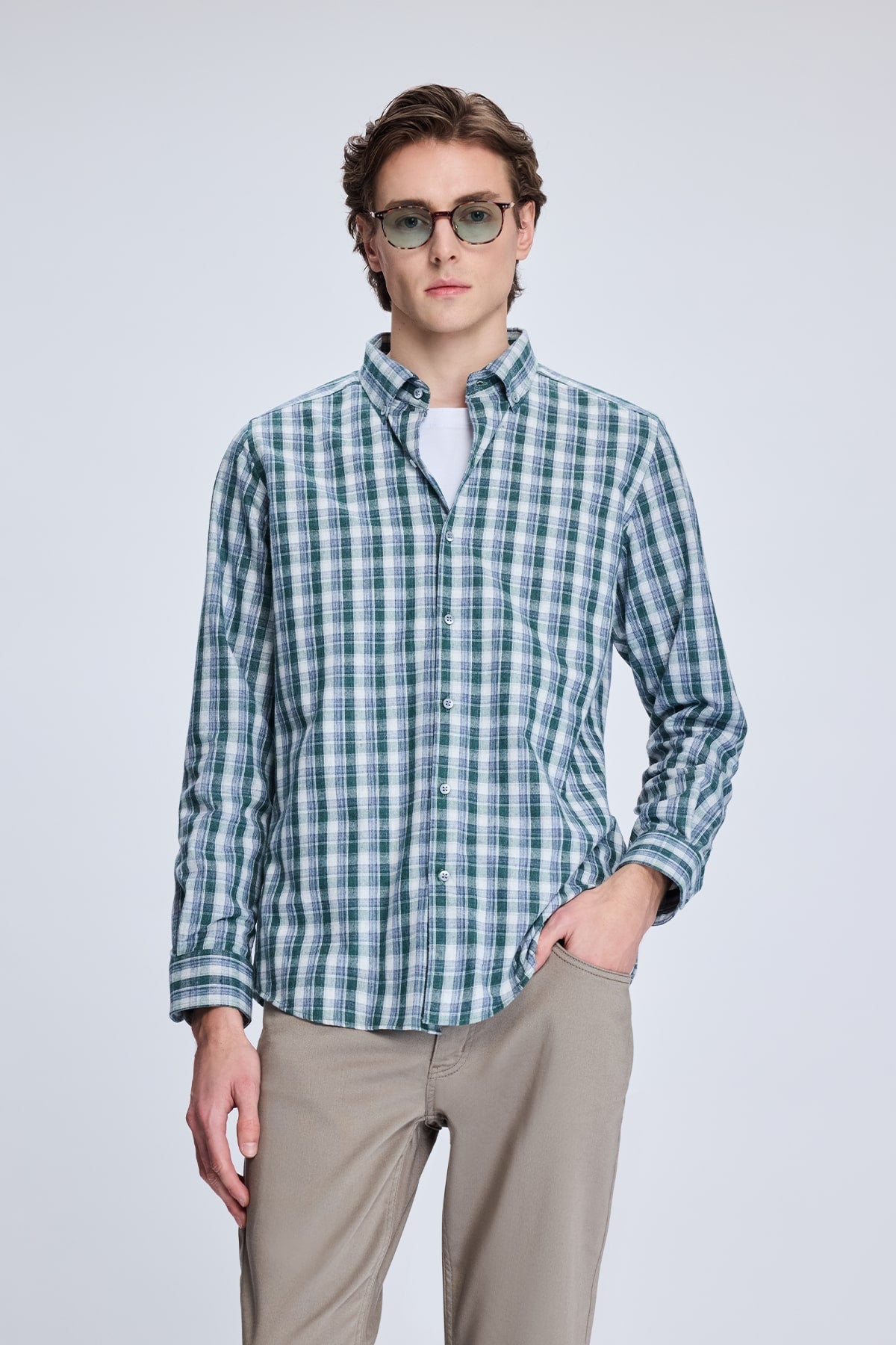 A men’s long-sleeved button-up shirt in a green and white plaid pattern, made of lightweight fabric with neatly finished cuffs.