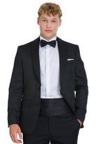 Slim fit black tuxedo with shawl lapel, textured fabric, matching trousers, and satin bow tie for evening events