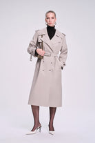 Beige trench coat with double-breasted front, belted waist, and structured shoulders.