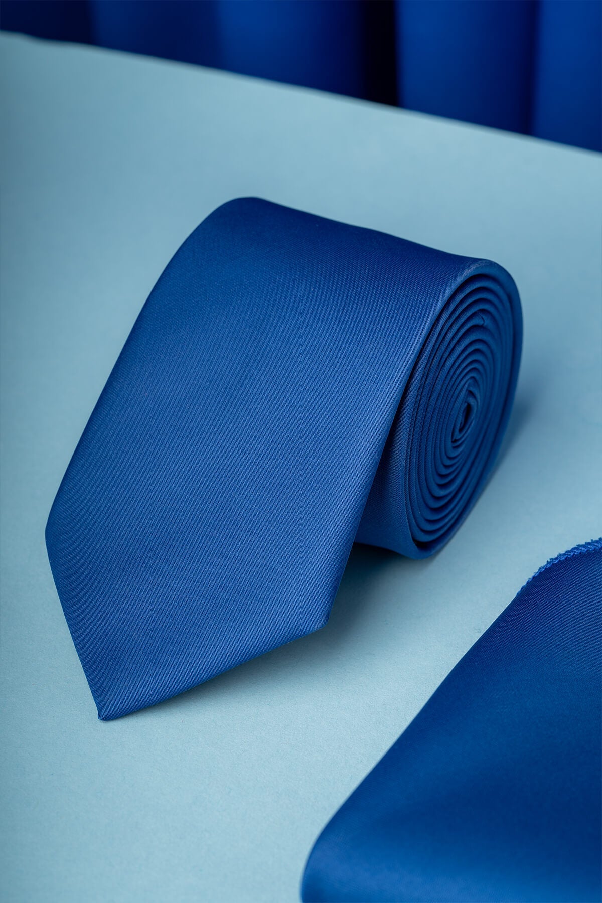 A sleek, solid royal blue silk tie with a subtle woven texture.