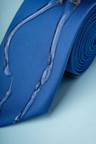 A vibrant royal blue silk tie featuring a subtle, translucent design resembling flowing liquid or glass strands.