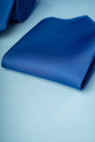 A rich royal blue silk pocket square, neatly folded and displaying a subtle sheen.