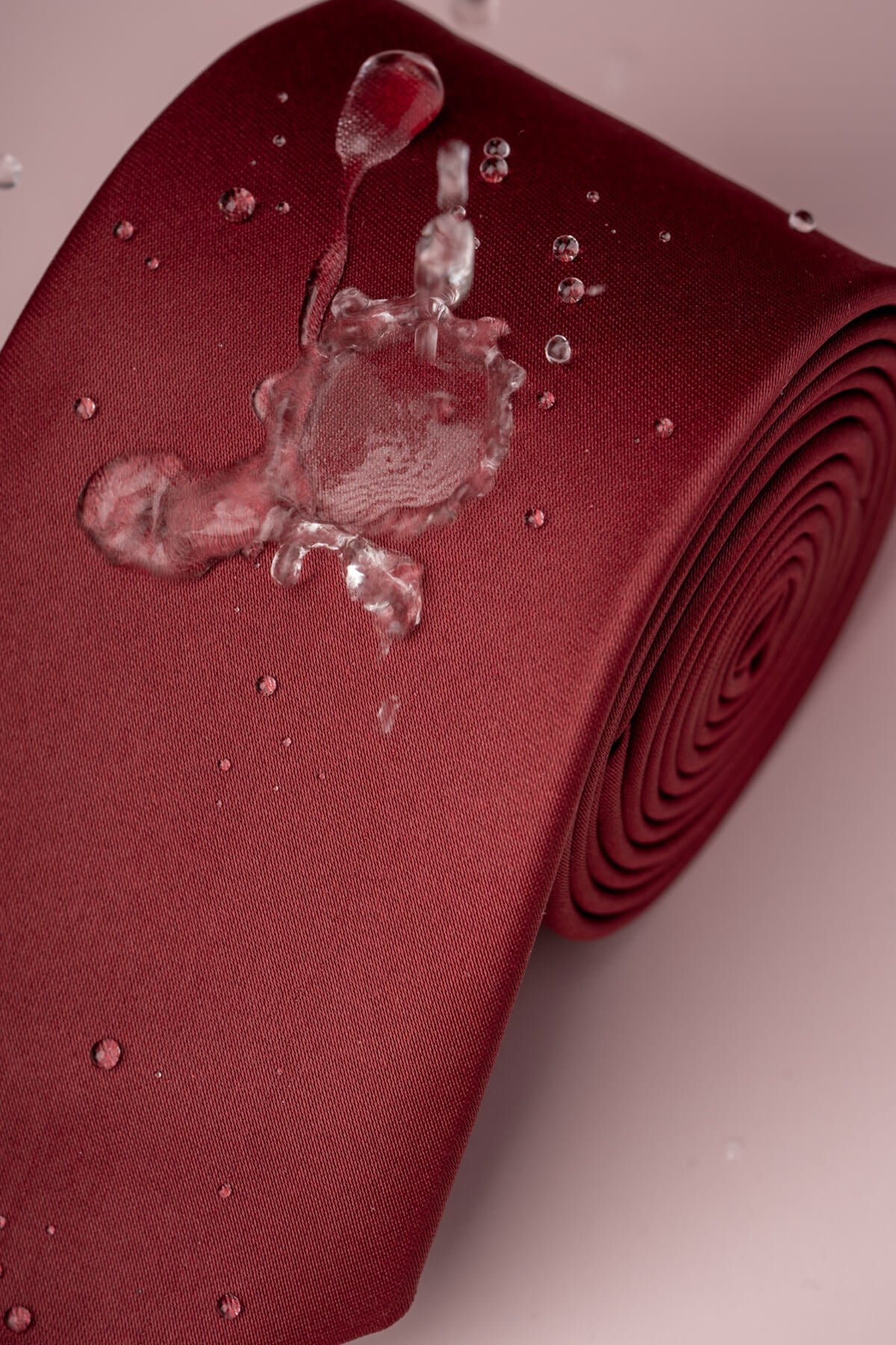 A rich burgundy satin tie with a sleek, smooth texture and subtle sheen.