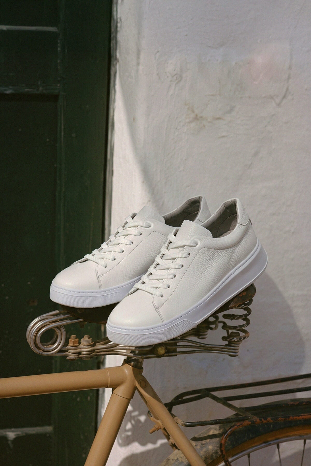 White pebbled leather lace up sneakers with clean minimalist design and matching white pebbled leather laces
