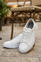White pebbled leather lace up sneakers with clean minimalist design and matching white pebbled laces
