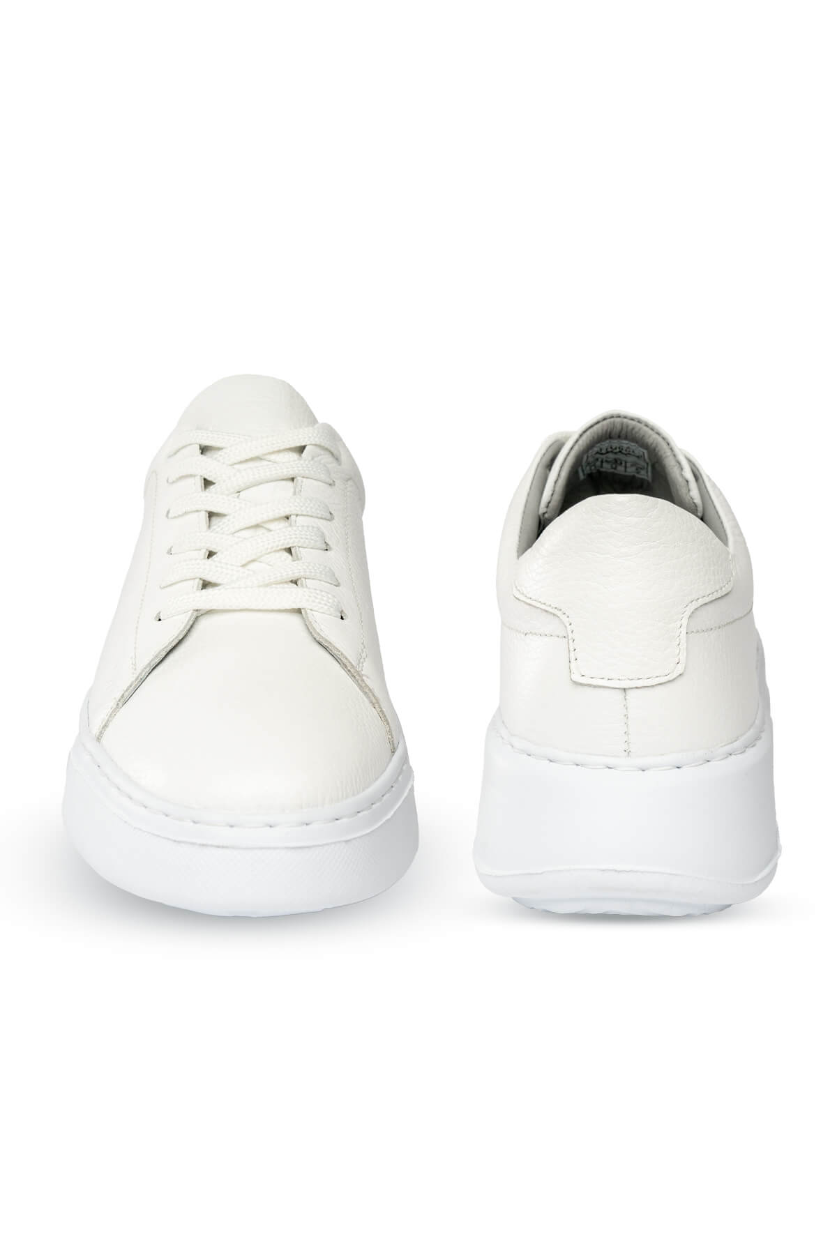 White leather sneakers with a clean, minimalist design and chunky soles.